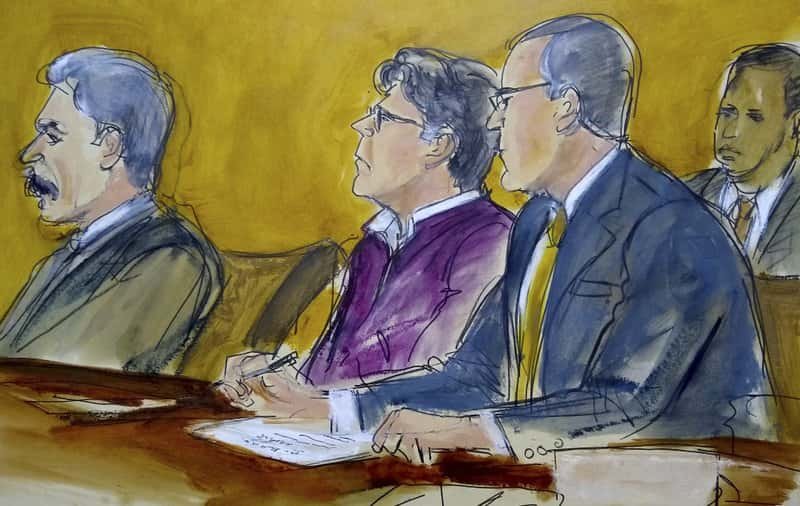 In this courtroom drawing, defendant Keith Raniere, center, sits at the defense table with his attorneys Paul DerOhannesian, left and Marc Agnifilo, as the jury foreperson reads the guilty verdict in his sex trafficking trial in New York, Wednesday, June 19, 2019. The former leader of a cult-like self-help group was convicted Wednesday of manipulating his female followers through shame and humiliation and turning them into what prosecutors call his sex slaves. The man at the rear is a Deputy US Marshal. (Elizabeth Williams via AP)